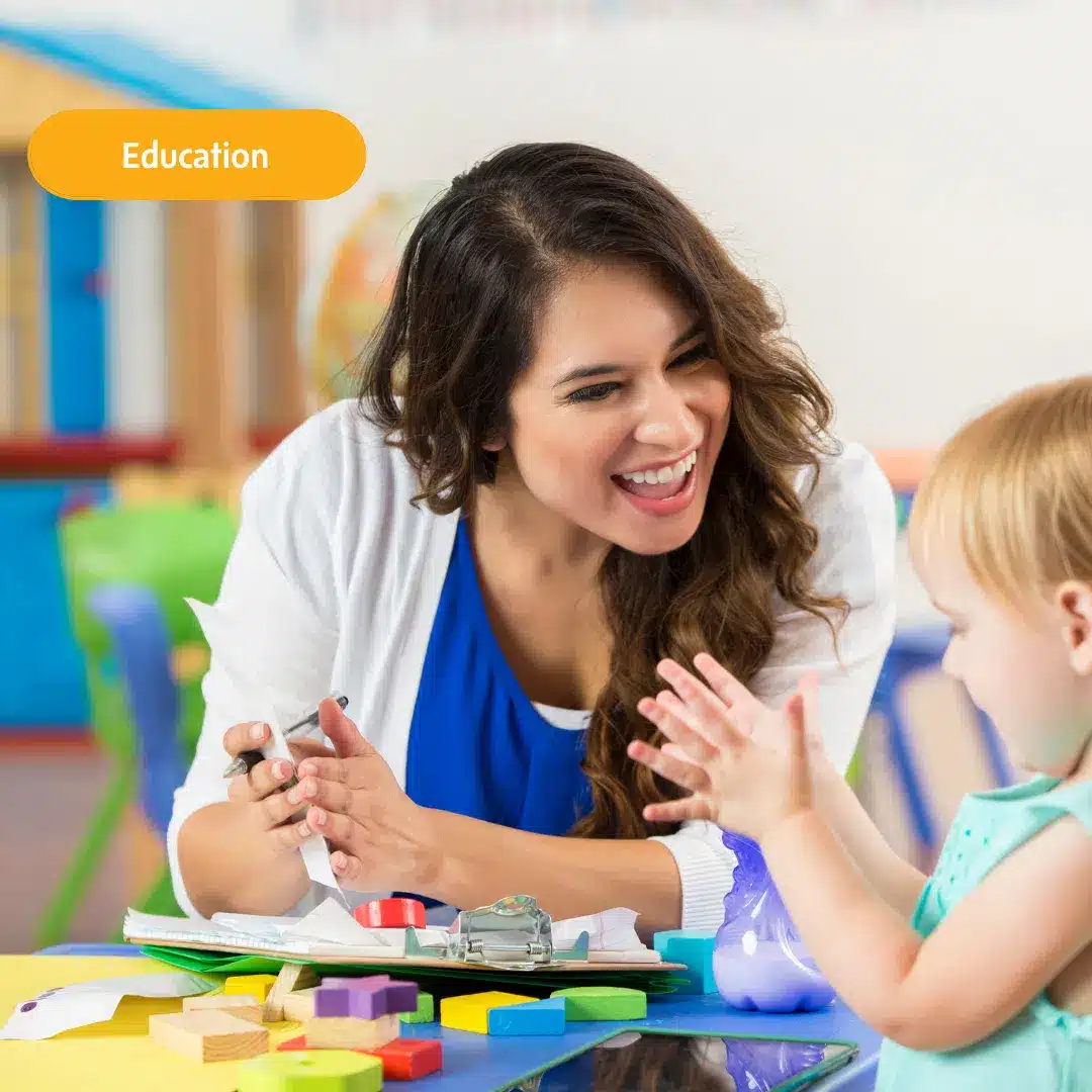 Éducation, avec une enseignante souriant à une élève, illustrant la relation positive et bienveillante dans l'apprentissage