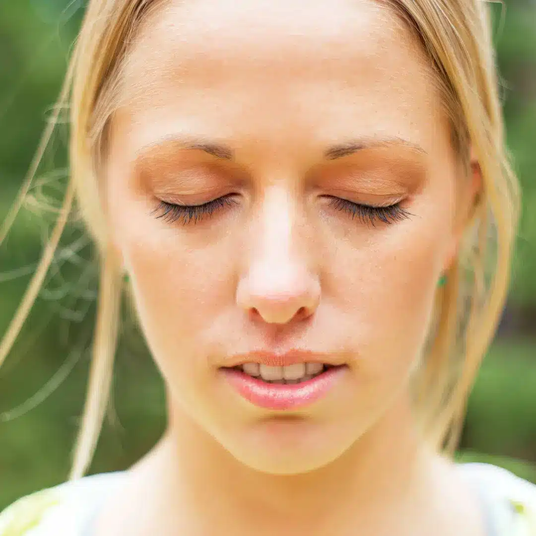 Femme en état méditatif, regardant droit devant elle les yeux fermés