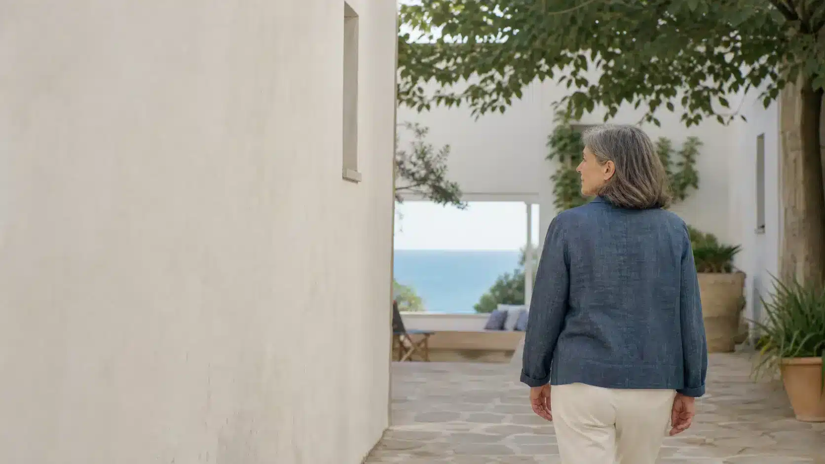 Femme avançant vers un patio ouvert sur la mer à Altafulla