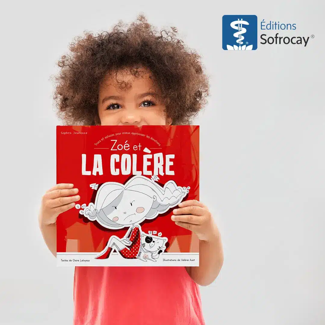 Un enfant avec des cheveux frisés, tenant dans ses mains le livre Zoe et la colère des éditions Sofrocay, couverture rouge